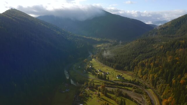 Breathtaking bird's eye view of the serene Prut River valley nestled between evergreen mountain slopes. Carpathian mountains, Ukraine.