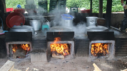 가마솥에 불을 피워 요리를 하고 있는 모습 