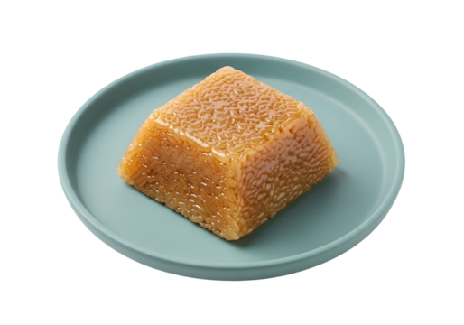 A square block of golden-hued cooked rice sits on a light teal plate against a black background.