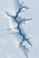 Deep snow crack forming natural icy crevasse