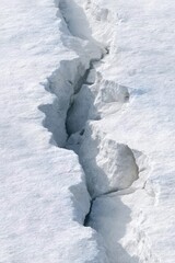 Wide frozen ground crack in thick snowy surface
