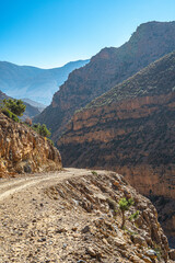Scenic canyon landscape in Morocco’s Atlas Mountains with rugged rock formations riverbed and mountain backdrop creating dramatic desert view