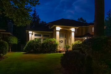 Two story stucco luxury house with big tree and nice landscape at night at Summer in Vancouver, Canada, North America. July 2025.