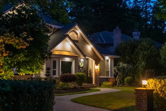 Two story stucco luxury house with big tree and nice landscape at night at Summer in Vancouver, Canada, North America. July 2025.