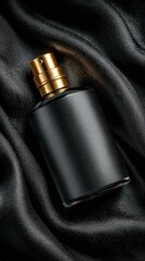 Black perfume bottle with golden sprayer on fabric background