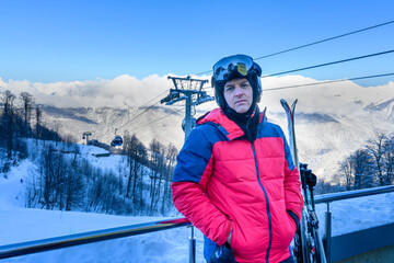 A skier in front of snow-covered mountains, getting ready for a descent
