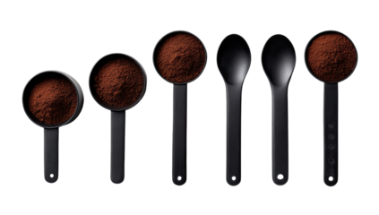 Dark cocoa powder in black measuring cups and spoons
