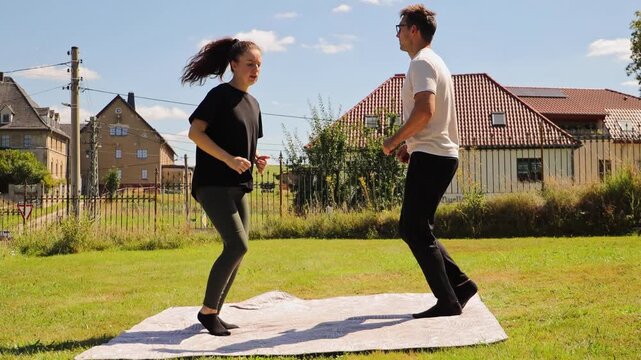 A couple engages in various sport exercises in their backyard, focusing on fitness while having fun together. Their playful interactions highlight their strong bond and shared interests