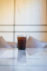 A black iced coffee or iced Americano on the table at a coffee shop.