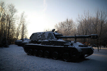 Military tank in a row. Battle tank in the snow on the roadside of highway. War in Ukraine in winter.