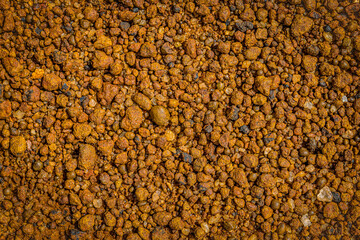 Dark gravel scattered on a dusty dirt road  textures , creating textural contrast, brown, grey
