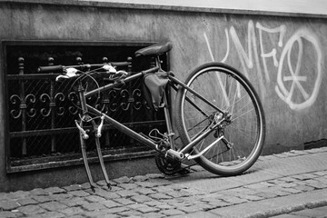 Derelict bicycle abandoned on the street. Captured on a B&W film. Vintage style.