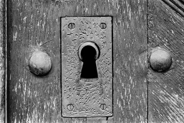 Keyhole. Detail of ancient door captured on a B&W film. Vintage style.