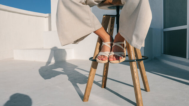 Woman's feet in sandals on a stool - Powered by Adobe