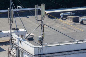 Fototapeta premium A close-up view of a mobile communication antenna installation on a flat roof, ideal for illustrating modern telecommunications technology, network infrastructure, or urban digital connectivity concep