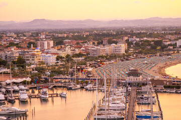 Obraz premium Sea port of Italian city of Rimini beach resort on coast top view. Hotels apartments. Italy holidays. Yachts and ships in the bay at sunset in the evening