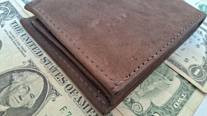 Leather wallet and us dollar bills