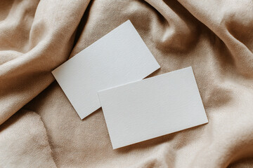 A high quality photography of blank business card or shop card for mock-up and presentation. beige fabric background.