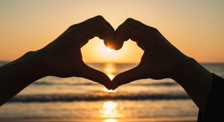 Hands forming a heart shape around a sunset over the ocean