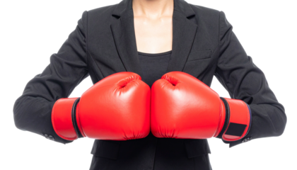A determined woman ready to fight in the business world, wearing boxing gloves. The woman is positioned ready for a contest.