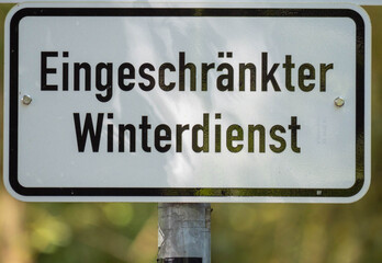 Warning Sign with German Text "Eingeschr&auml;nkter Winterdienst" in a Forest