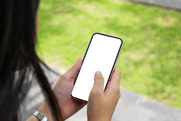 Woman or girl holding phone blank outdoor on a white wall. Phone mockup	