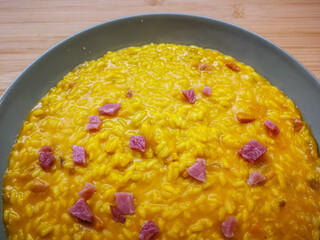 Background with a plate of pumpkin and speck risotto