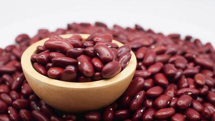 Raw Red Kidney Beans in Wooden Bowl on Pile of Beans Background