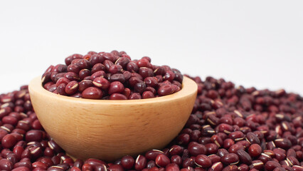 Raw Red Adzuki Beans in Wooden Bowl on Pile of Beans Background