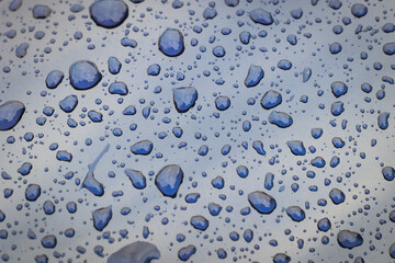 Close up on a rain drops on a car body surface