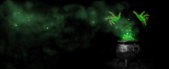 Witch's hands over a cauldron with a magic potion in a dark room. Witch casting spells on Halloween...