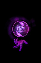 Obraz premium Fortune teller hand casting a spell over a crystal ball for divination, foresight, Halloween ritual in the darkness of the night