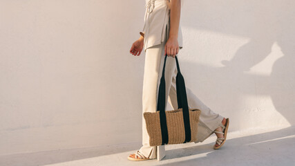Woman carrying tote bag walking in the sunshine