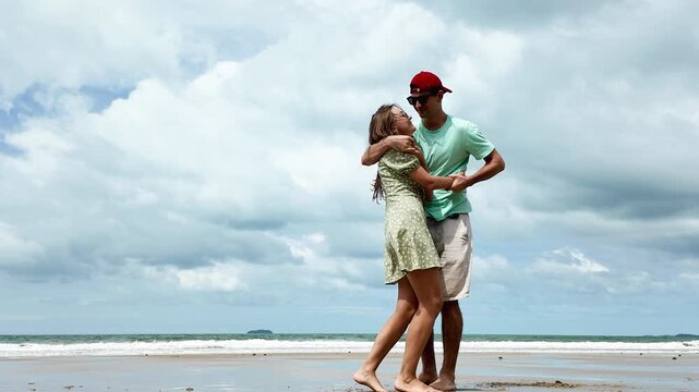 Happy caucasian couple having fun at the beach together. smiling beautiful young couple pending time together at the beach