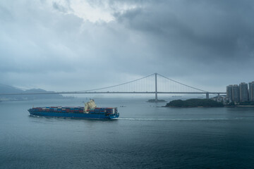 Cargo ship under cloudy sky on calm sea