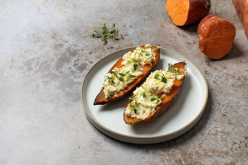 Baked sweet potatoes with ricotta and fresh herbs. Healthy and vegan food