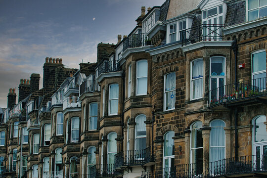 Row of brick buildings with bay windows and balconies in Scarborough, UK.