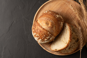 Artisanal Sourdough Bread on Wooden Plate with Wheat Ears, bakery and bread concept