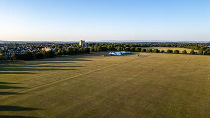 Aerial View of Grassy Field with Distant Buildings and Trees  in Harrogate, UK.