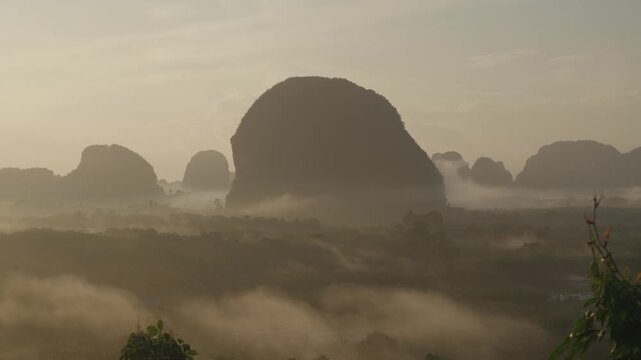Sunrise view with mist over mountains and forest at Din Daeng Doi, Krabi, Thailand, creating a serene and dramatic natural landscape.