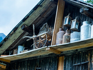 articles de brocante, poussette, pot à lait, sous une charpente de chalet d'alpage, patrimoine...
