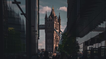 Dramatic view of Tower Bridge framed by modern buildings.