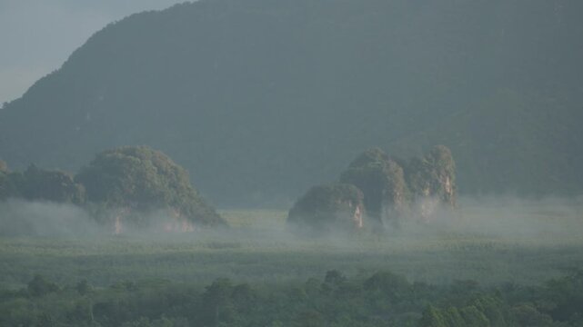 Sunrise view with mist over mountains and forest at Din Daeng Doi, Krabi, Thailand, creating a serene and dramatic natural landscape.