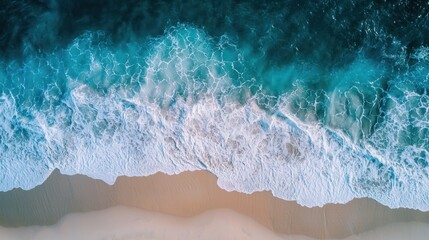 Obraz premium Aerial view of a beach with waves crashing onto the shore.