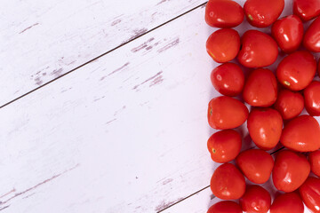 Strawmato variety tomatoes, on white-washed distressed wood surface, with copyspace