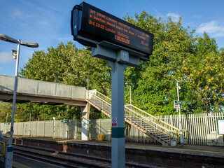 Train station sign with blue sky overhead