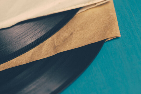 Close-up of two vintage vinyl records in record sleeves on a blue background