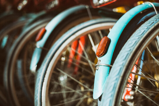Close-up of the rear wheels and reflector lights of a row of bicycles parked side by side, Silicon Valley, California, USA