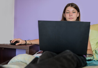 Beautiful young girl working or communicating with her laptop