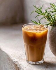 Iced Coffee in Glass on Minimalist Concrete Surface with Planter